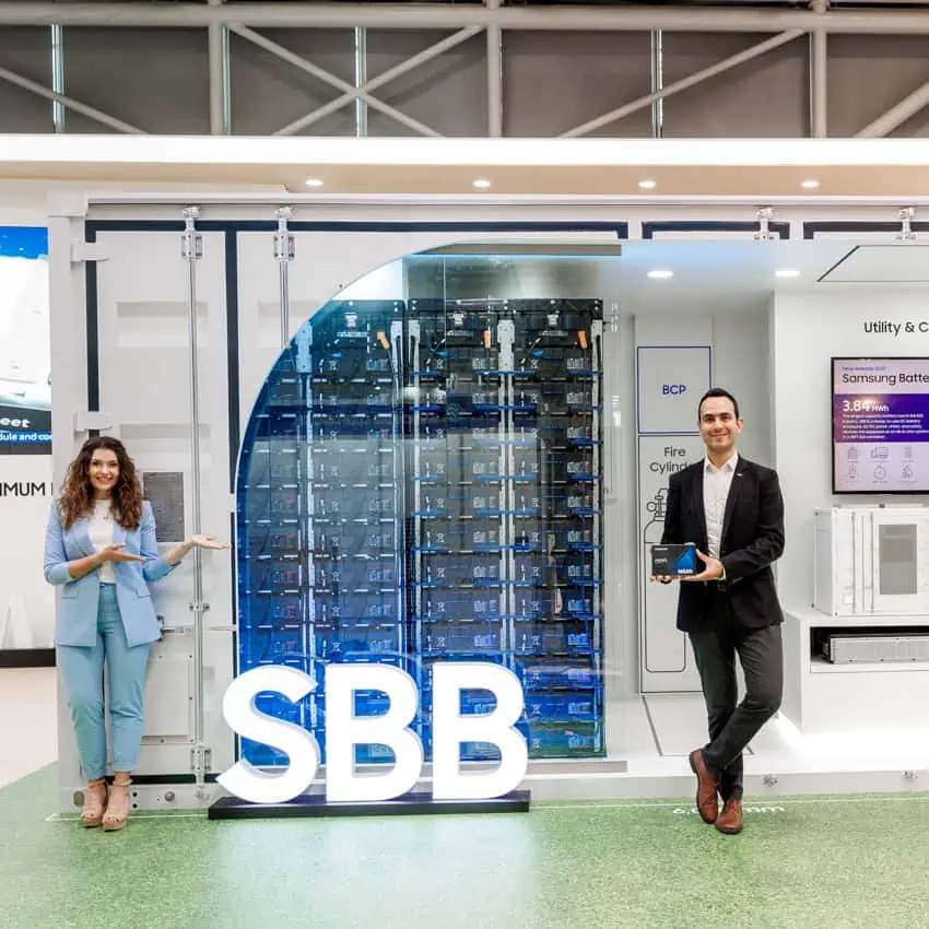 Zwei Personen stehen neben einer transparenten Anzeige mit technologischen Geräten und der Aufschrift "SBB".