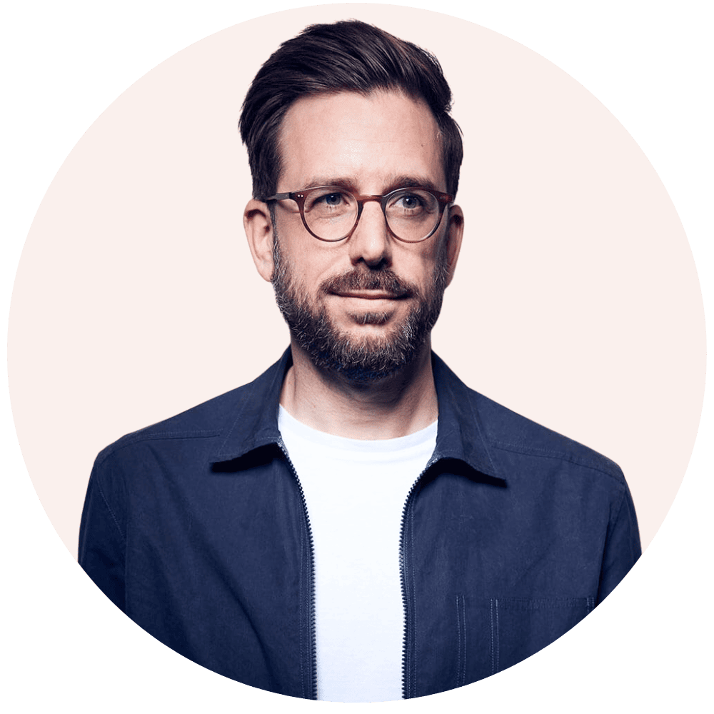 Das ist ein Porträtfoto einer männlichen Person mit Brille und Bart.