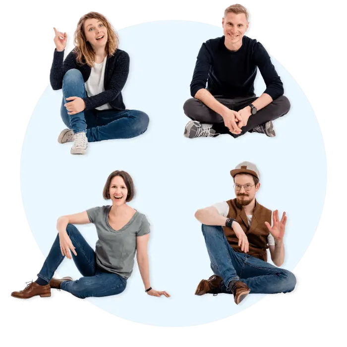 Das Bild zeigt vier lächelnde Personen, die auf dem Boden sitzen und unterschiedliche Posen und Gesten machen.