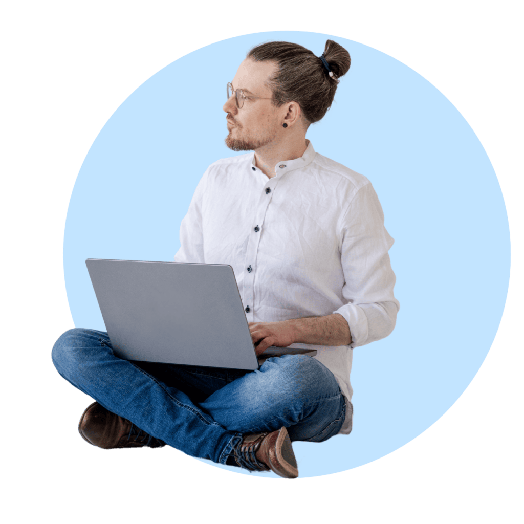 Das Bild zeigt einen modernen, fokussierten Mann, der im Schneidersitz vor einem Laptop sitzt und in Gedanken versunken ist. Dies spiegelt den aktuellen Trend des Remote-Arbeitens und kreativen Denkens wider, ideal für Themen wie digitale Nomaden und Homeoffice.