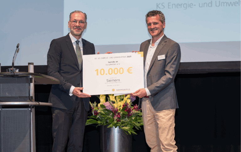 Auf dem Bild wird eine feierliche Spendenübergabe im Rahmen des 43. KS Energie- und Umweltpreises 2025 dargestellt, bei der eine Summe von 10.000 € an den Verein Sozialhelden e.V. übergeben wird. Prominente Sponsoren, darunter Siemens, unterstützen damit innovative soziale Projekte und fördern nachhaltige Lösungen für umweltbewusste Initiativen.